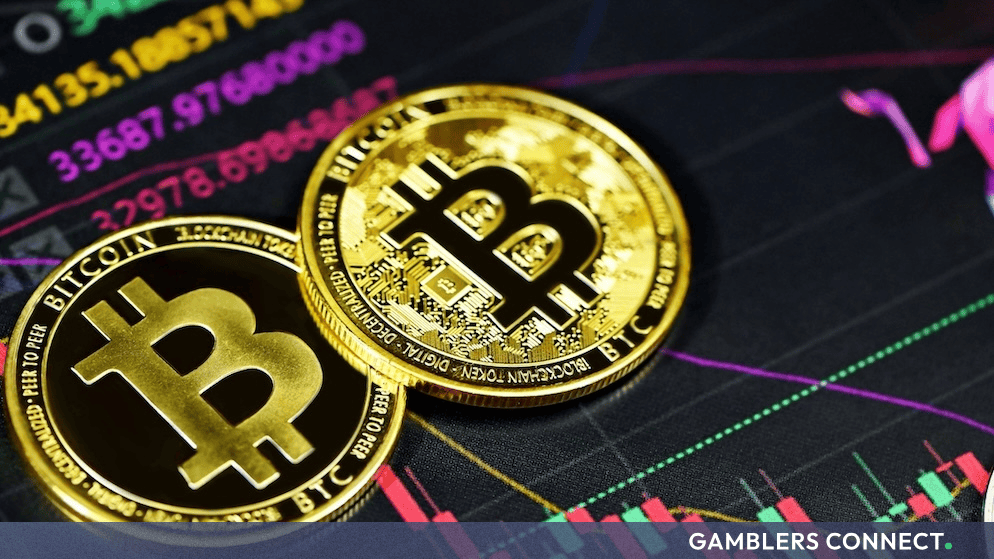 Physical Bitcoin tokens resting against a digital trading chart background illustrating cryptocurrency market movements.
