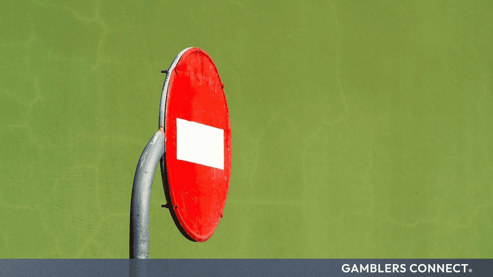 A red and white road sign positioned against a solid green background, symbolizing legal barriers and court decisions.