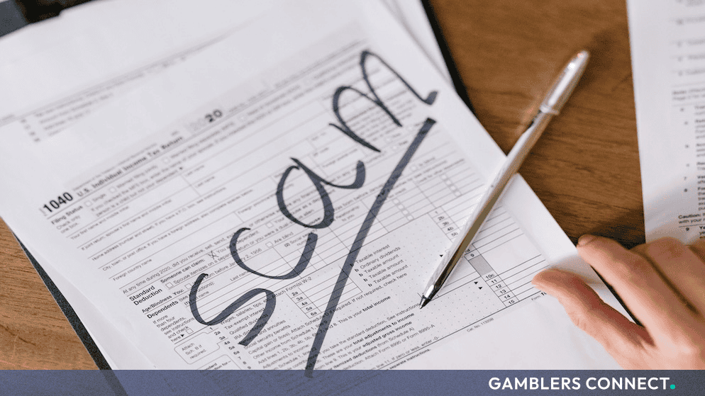 Curaçao Gaming Authority Issues Public Warning Over Unregulated Clone Domains Impersonating Famagousta B.V. 1 A close-up view of official paper documents on a wooden desk, with a pen resting on a tax form where the word "SCAM" is prominently written in bold black marker.