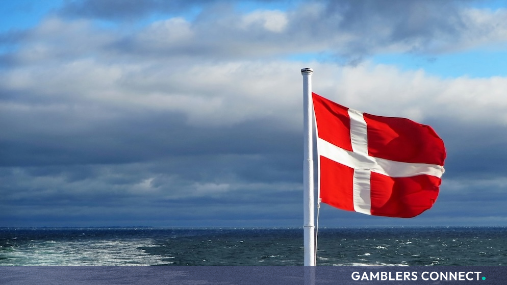 Spillemyndigheden Urges Danes to "Send Your Game on Summer Vacation" in New ROFUS Campaign 1 The Dannebrog flag waving in the wind above open ocean waters, representing Denmark's nationwide ROFUS self-exclusion program.