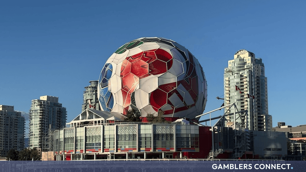 Large decorative football structure installed near waterfront urban architecture during international tournament celebrations.