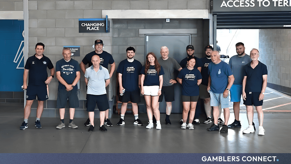 Group photo of Flutter volunteers alongside participants of the Leeds Rhinos Foundation community health programmes at AMT Headingley Stadium.