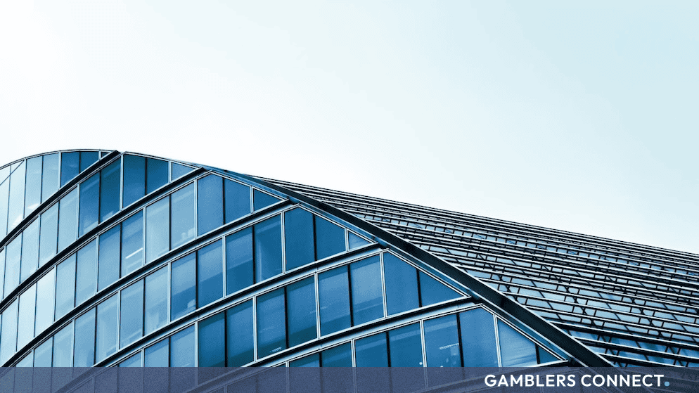 Gaming Corps Expands Entain Partnership to Target Canada and New International Markets 1 Exterior of a contemporary glass office building tower, representing corporate compliance and expansion across newly regulated international gambling markets.