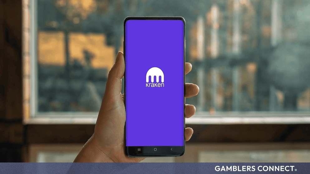 Kraken Targets European Banking License via Lithuania to Deepen FinTech Integration 1 Hand holding a smartphone running the Kraken platform interface, illustrating digital banking and cryptocurrency integration.