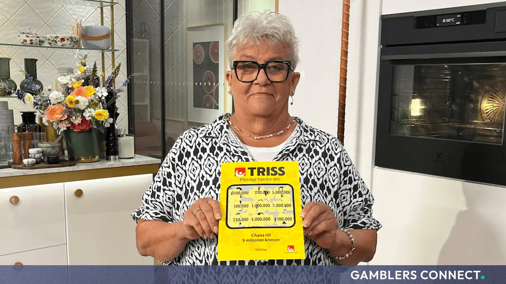 Eskilstuna Resident Lena Secures 100,000 Kronor Triss Win Live on TV4 Nyhetsmorgon 1 Lena from Eskilstuna, a smiling woman with short silver hair and black glasses, stands in a modern TV kitchen holding a large yellow Triss scratch card showing a live television win of 100,000 kronor.
