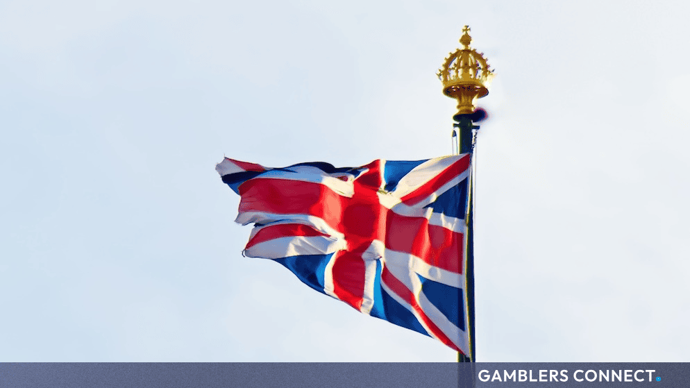 APPG Co-Chair Alex Ballinger Calls for New UK Gambling Act and 40% Machine Games Duty Hike 1 Low-angle close-up of the British flag blowing in the wind, representing macroeconomic gambling tax policy changes and parliamentary debates in London.