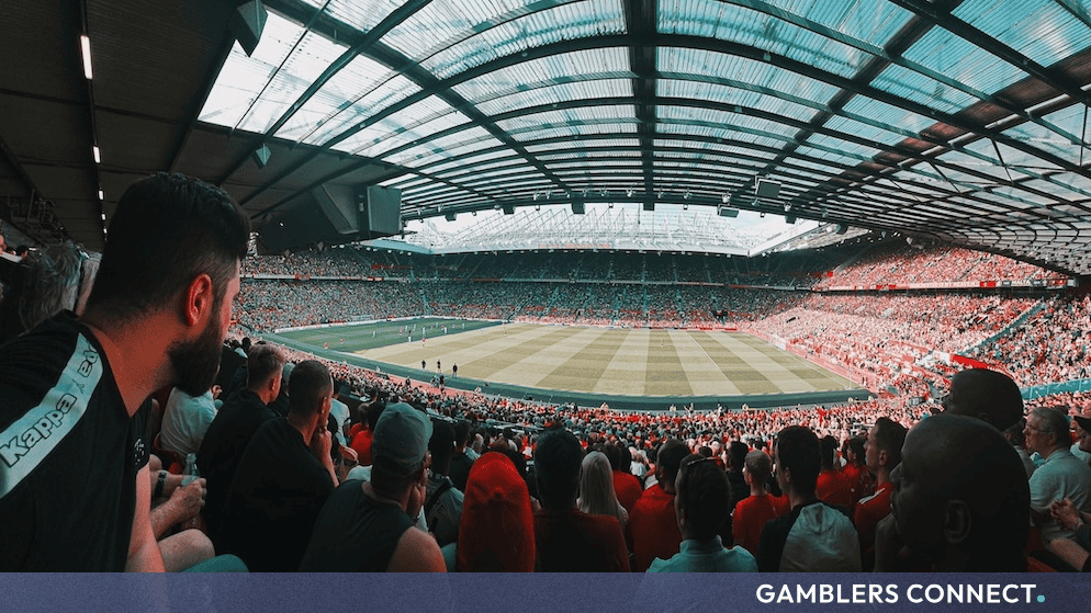 Manchester United Unveils Location and Masterplan for Proposed 100,000-Seater "New Trafford" Stadium 1 Thousands of football fans filling the red seats of Manchester United's stadium during a live match, highlighting the current architectural roof lines and seating capacities.