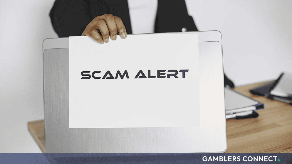 An official scam alert notification card positioned in front of computer hardware, symbolizing the intersection of digital marketing fraud and cybercrime auditing.