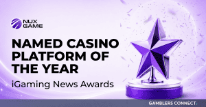 An official corporate announcement graphic featuring a light purple background with floating confetti, displaying a prominent 3D purple star trophy sitting on a circular silver and purple podium next to the white text 'NAMED CASINO PLATFORM OF THE YEAR' and the NuxGame corporate logo.