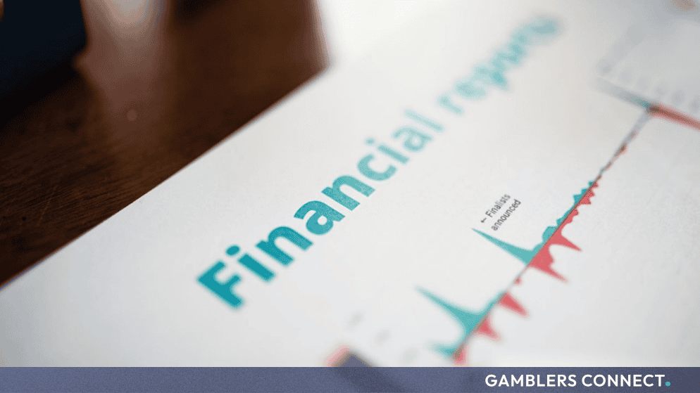 A printed financial report document with charts and text on a dark wooden table.