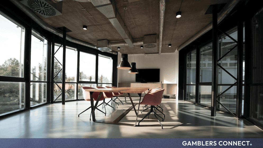 Sleek office meeting space with large windows and industrial ceiling elements symbolizing corporate transactions.