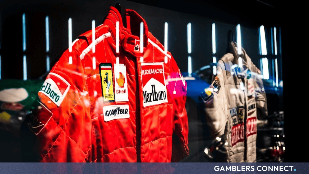 Side-by-side display of historic motorsport racing gear highlighting iconic corporate sponsors inside a specialized memorabilia exhibit.