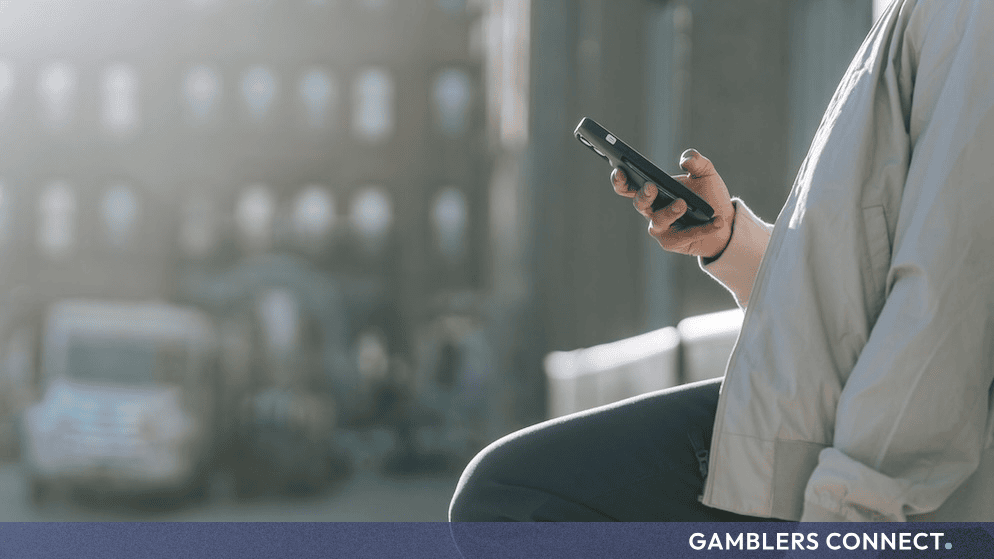 A person holding and browsing a smartphone outdoors, representing digital and social media news consumption.