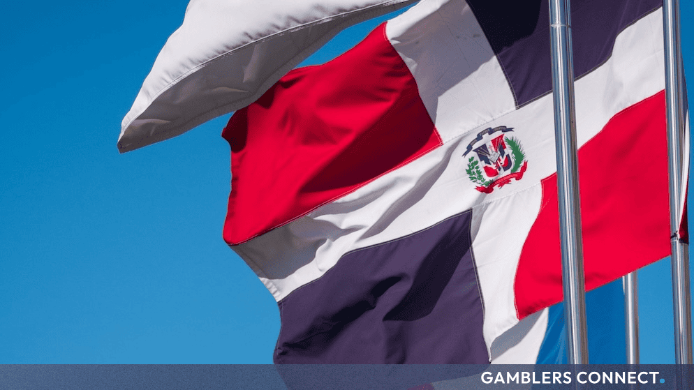 The national flag of the Dominican Republic waving against a clear blue sky, representing local market expansion.
