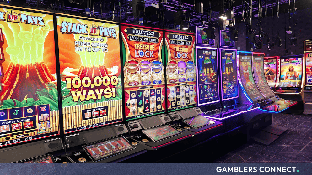 A row of physical slot machine cabinets in a studio environment featuring vibrant game screens, vibrant lighting, and control panels.