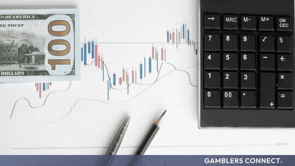A calculator, a stack of US dollar bills, and financial charts illustrating market performance data.
