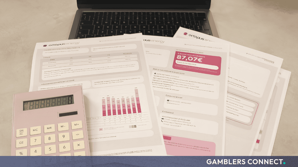 Financial documents and a calculator resting on a desk next to a laptop computer.