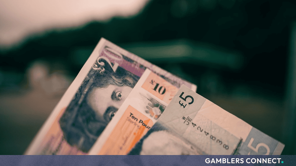 Close-up of British currency banknotes including five, ten, and twenty-pound notes representing regulatory fines and financial settlements.
