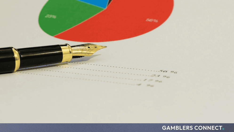A classic fountain pen resting on top of financial charts and demographic percentage data.
