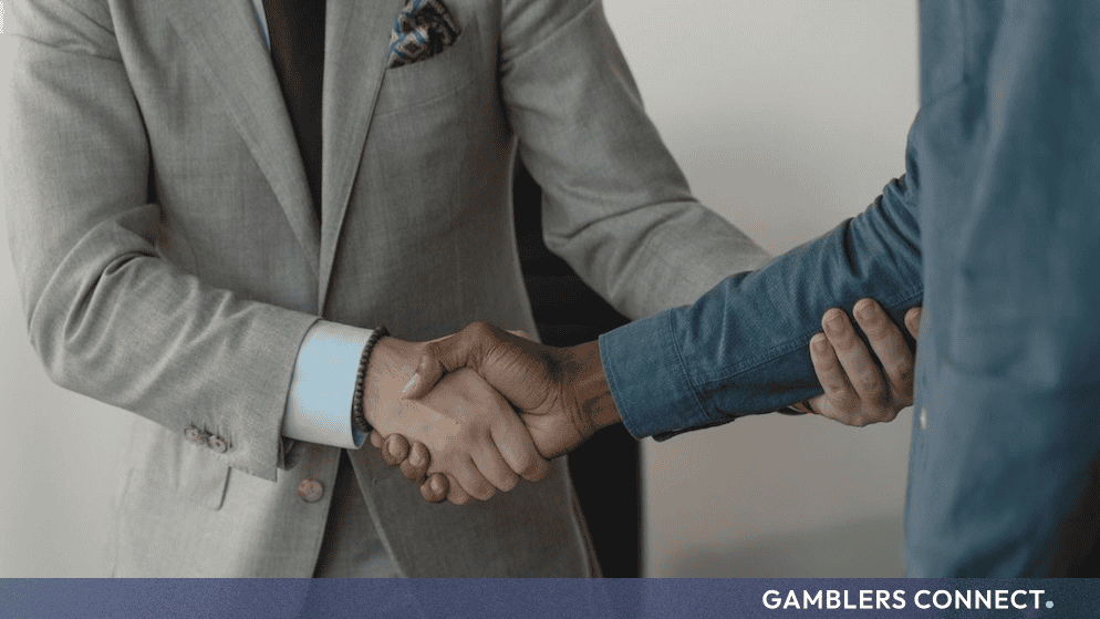 Two business professionals shaking hands in an office setting to finalize a corporate agreement.