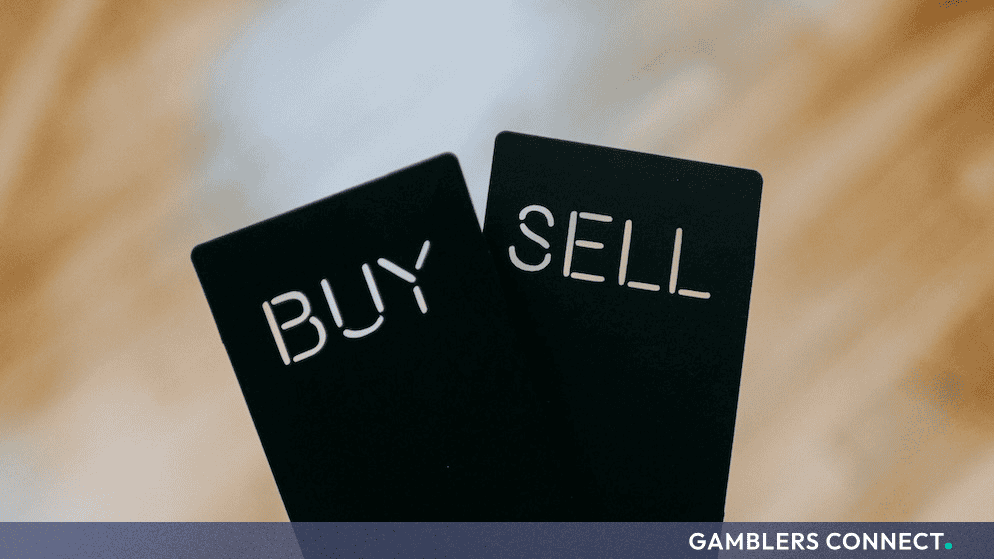 Black cards displaying the words BUY and SET against a wooden background, representing stock market trading and investment decisions.