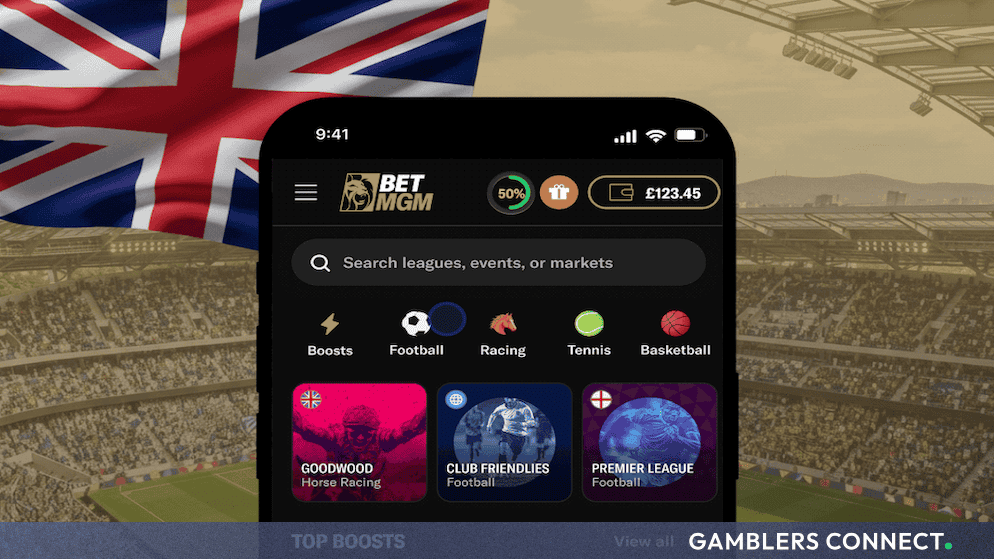 Mobile smartphone displaying the BetMGM sportsbook application interface against a background featuring a UK flag and football stadium.