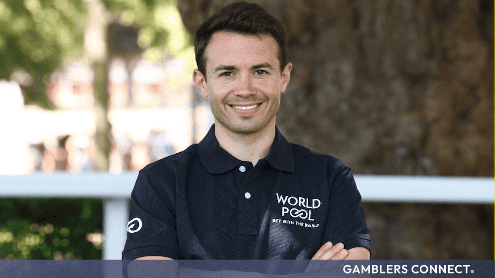 French Champion Jockey Mickaël Barzalona wearing a black World Pool branded polo shirt outdoors.