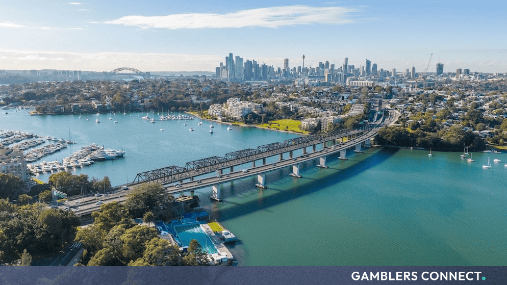 Aerial view of the Sydney Harbour Bridge, city skyline, and surrounding waterways in New South Wales.