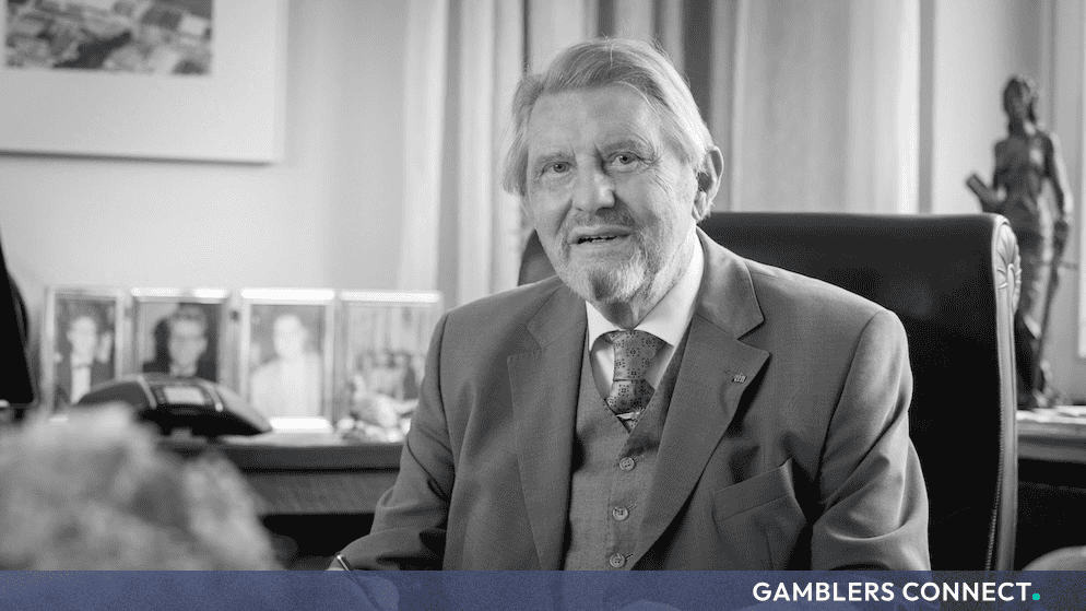 A classic black-and-white portrait of Paul Gauselmann seated at his executive desk working in his office.