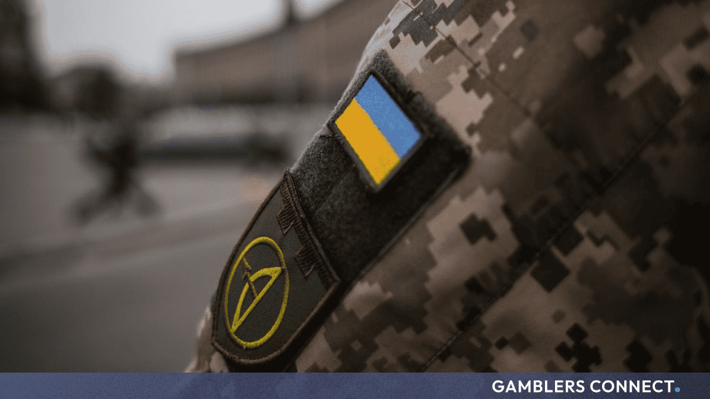 Close-up of a military uniform sleeve featuring the Ukrainian flag patch and insignia.