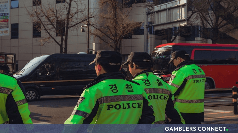South Korean police officers in high-visibility neon green and black uniforms patrolling an urban street.