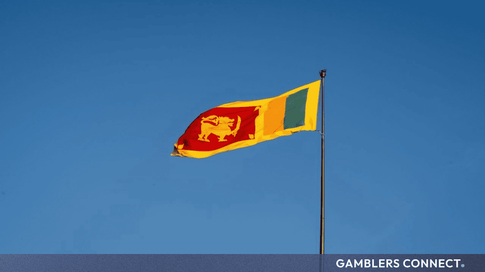 The national flag of Sri Lanka waving against a clear blue sky background.