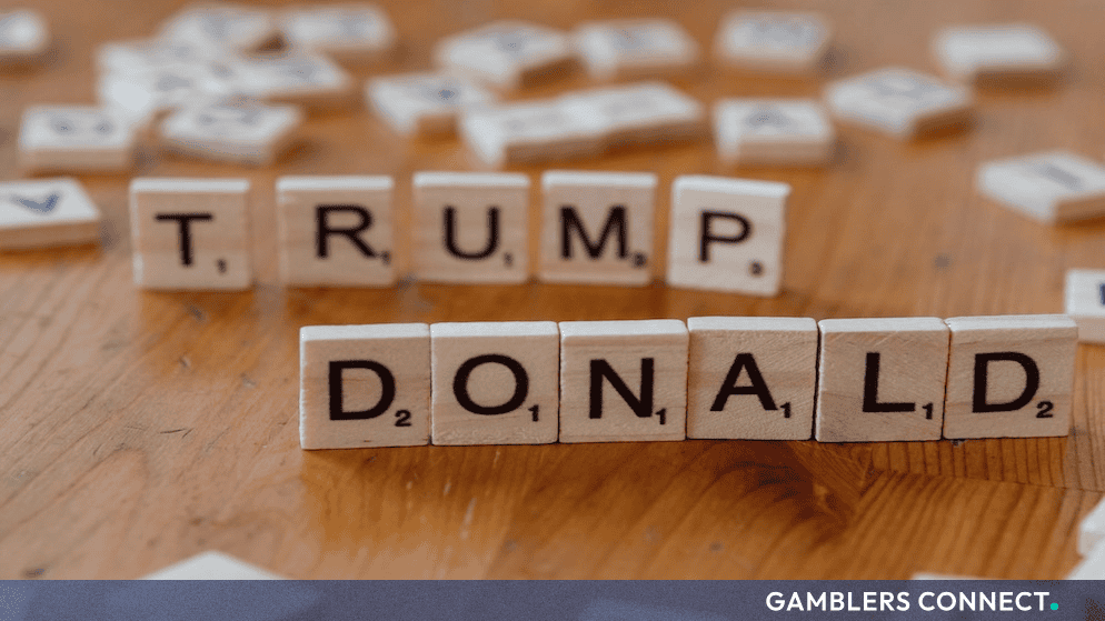 Scrabble tiles spelling out TRUMP and DONALD arranged on a wooden table.