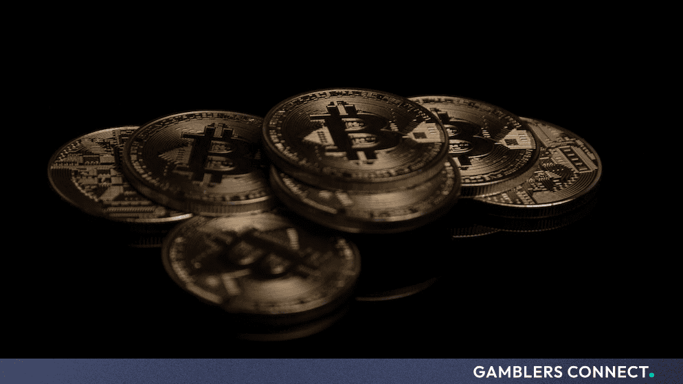 Golden physical Bitcoin tokens resting on a dark reflective surface, symbolizing federal cryptocurrency reserves and digital asset policy.