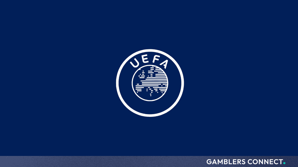 A match referee holding up an electronic substitution board featuring the official FIFA logo during a night football match.