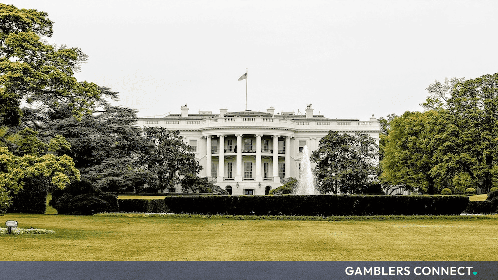 The exterior south facade of the White House in Washington, D.C., framed by lush green trees and a fountain in the foreground.