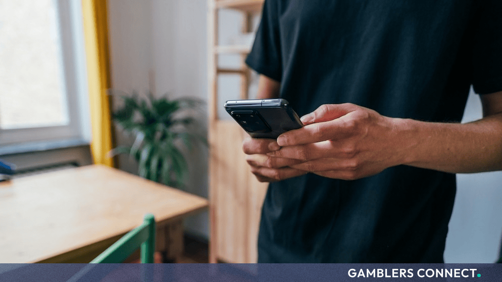 A person holding a smartphone device indoors while browsing online content.