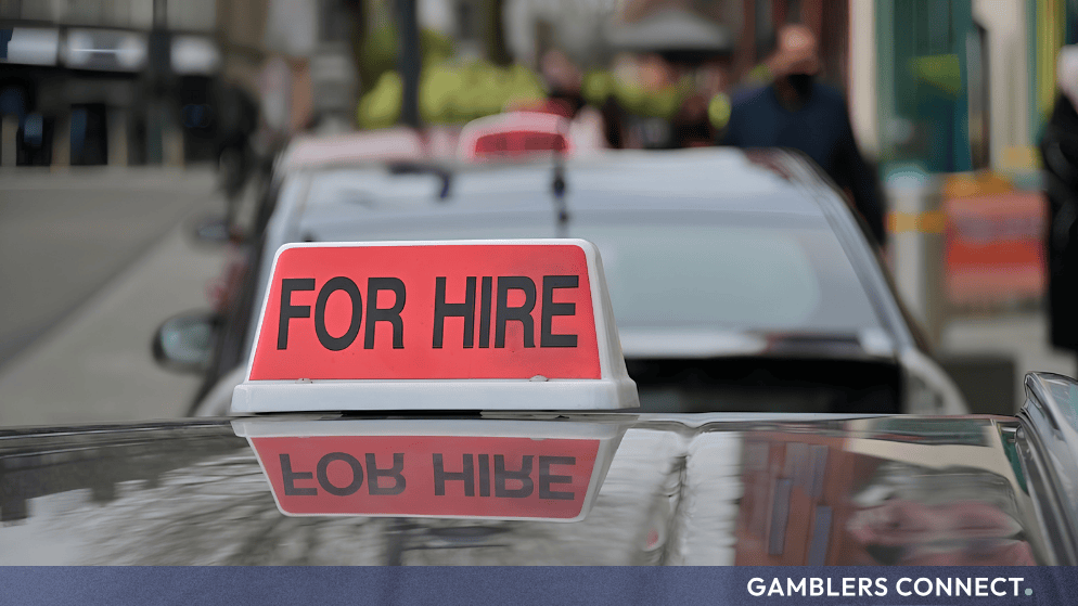 Close-up of a red "For Hire" taxi sign mounted on top of a vehicle, symbolizing executive recruitment and leadership changes.