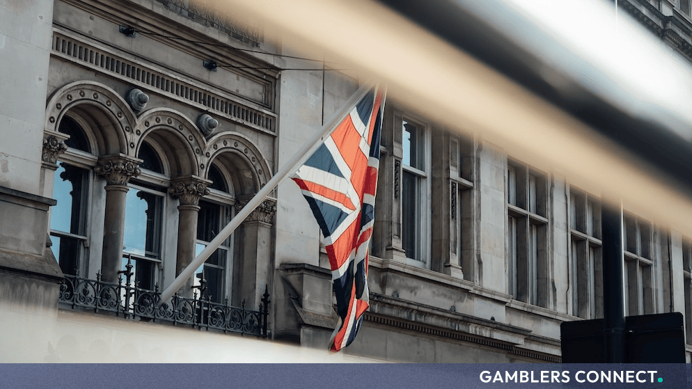 The Union Jack flag hanging outside a historic brick building in the United Kingdom.