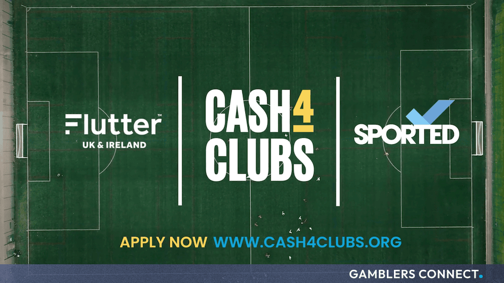 Aerial view of a green sports field displaying the Flutter and Sported Cash4Clubs promotional branding and website.