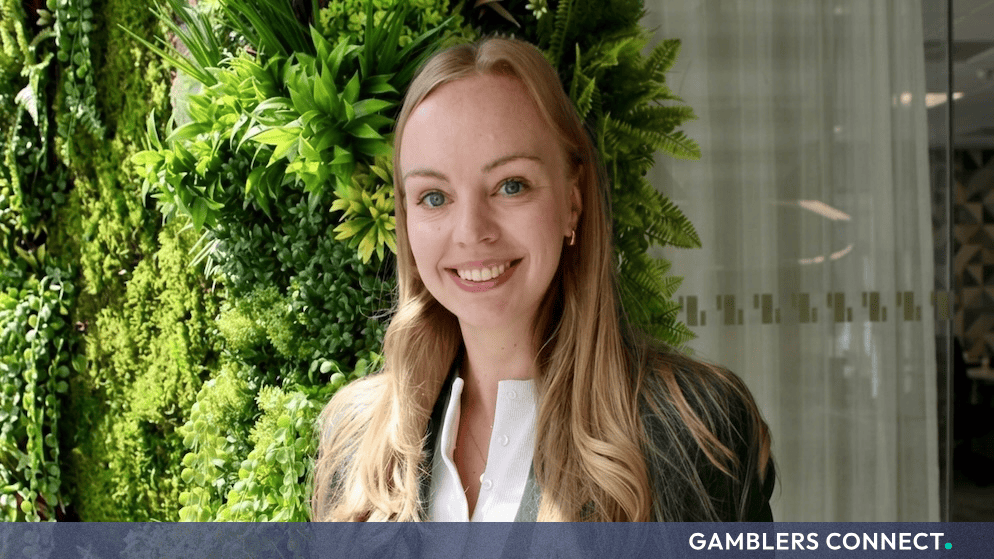 Professional headshot of Julia Waern, Chief Operating Officer at Hacksaw Studios, smiling in front of a green plant background.