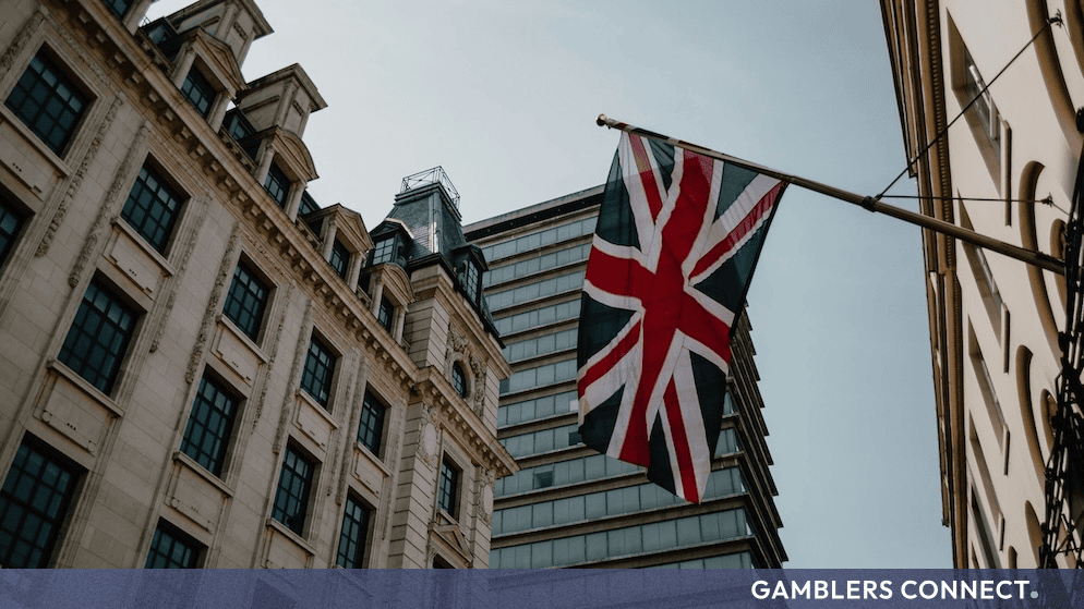 Classic British high street architecture featuring traditional buildings under a bright sky with a flying UK flag.