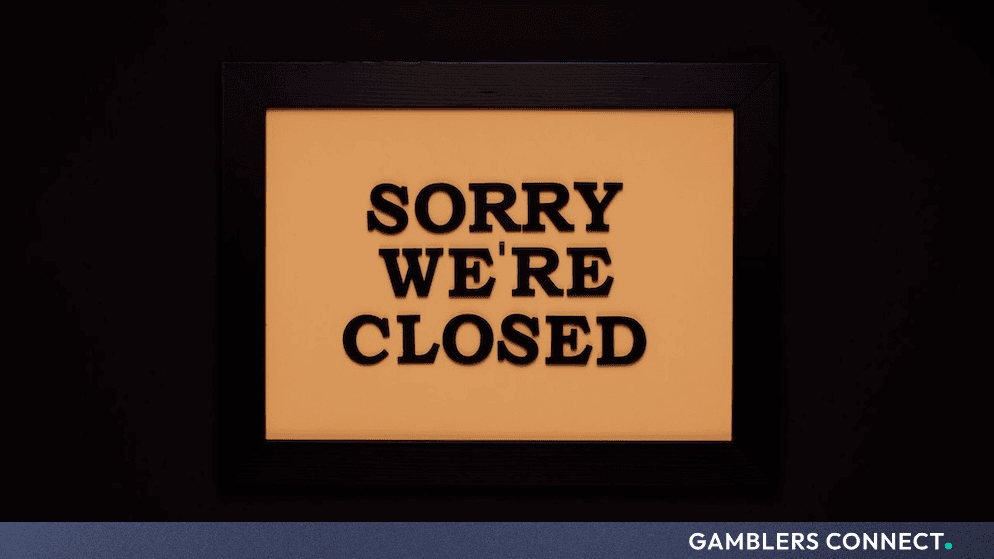 Framed sign with the text "Sorry We're Closed" against a dark background, representing business discontinuation.
