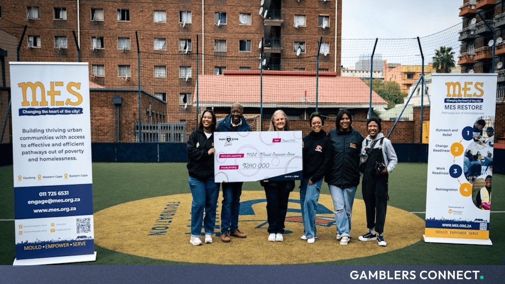Representatives from Super Group Cares and Betway Africa presenting a R110,000 donation check to the MES team outdoors in Johannesburg.
