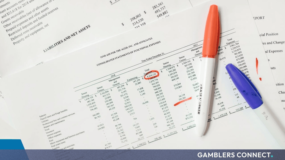 Financial statements and accounting sheets organized on a desk alongside markup pens and administrative tools.