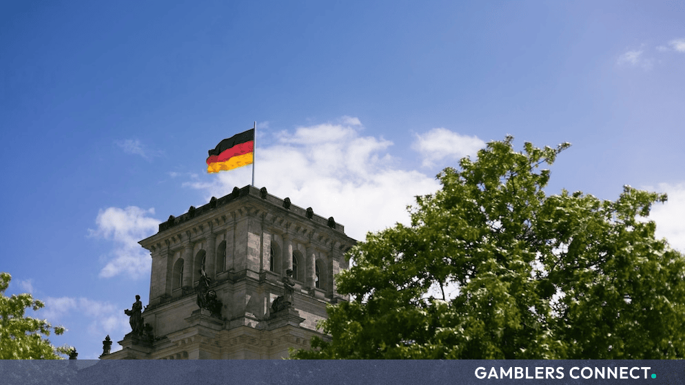 The German flag waving atop the Reichstag building in Berlin representing regulatory oversight and legal compliance in Germany