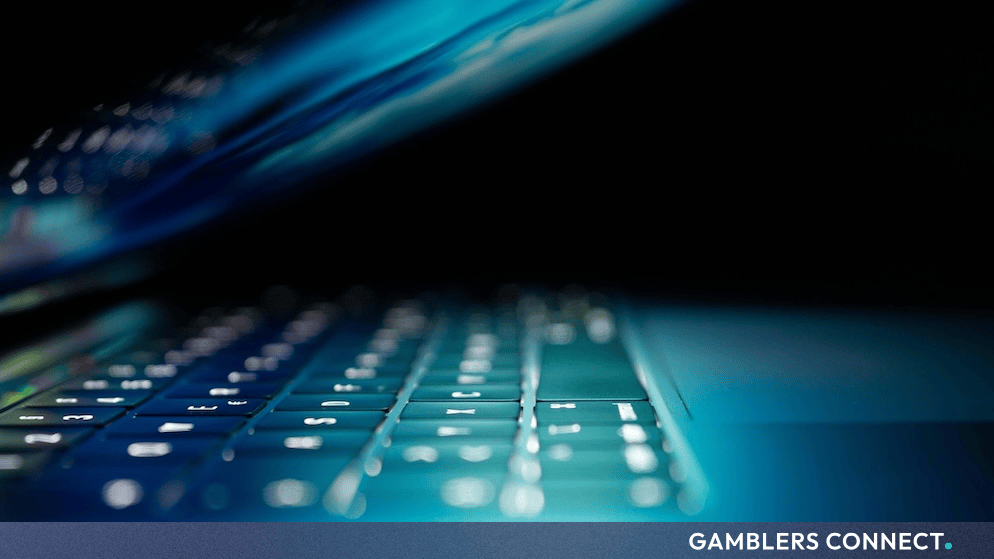 Laptop keyboard illuminated in blue light representing cybersecurity and data breach at Curacao Gaming Authority