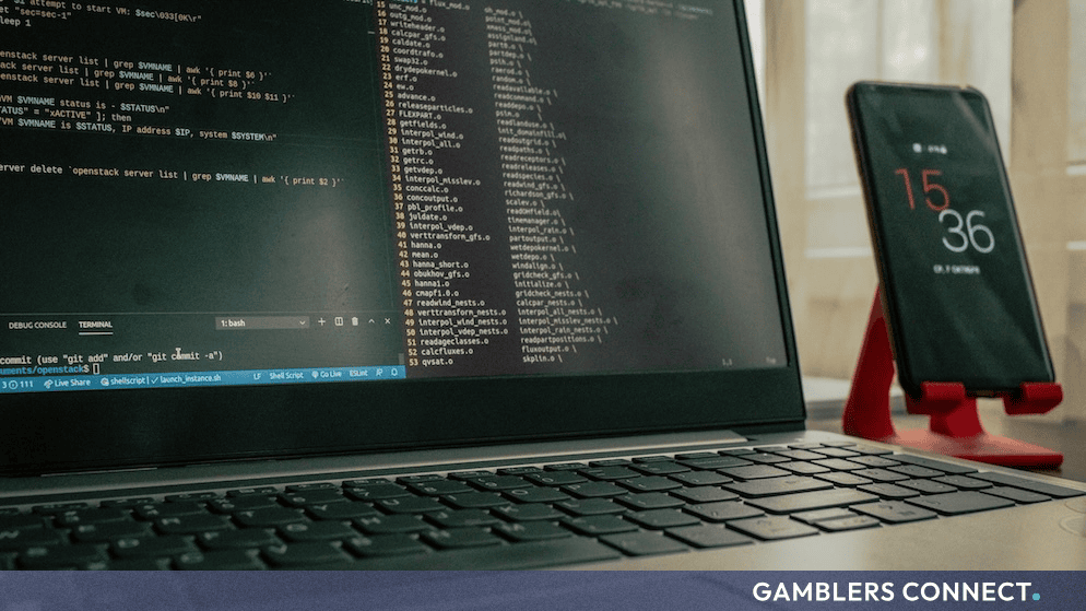 Laptop displaying terminal code alongside a smartphone representing cybersecurity risks and account protection
