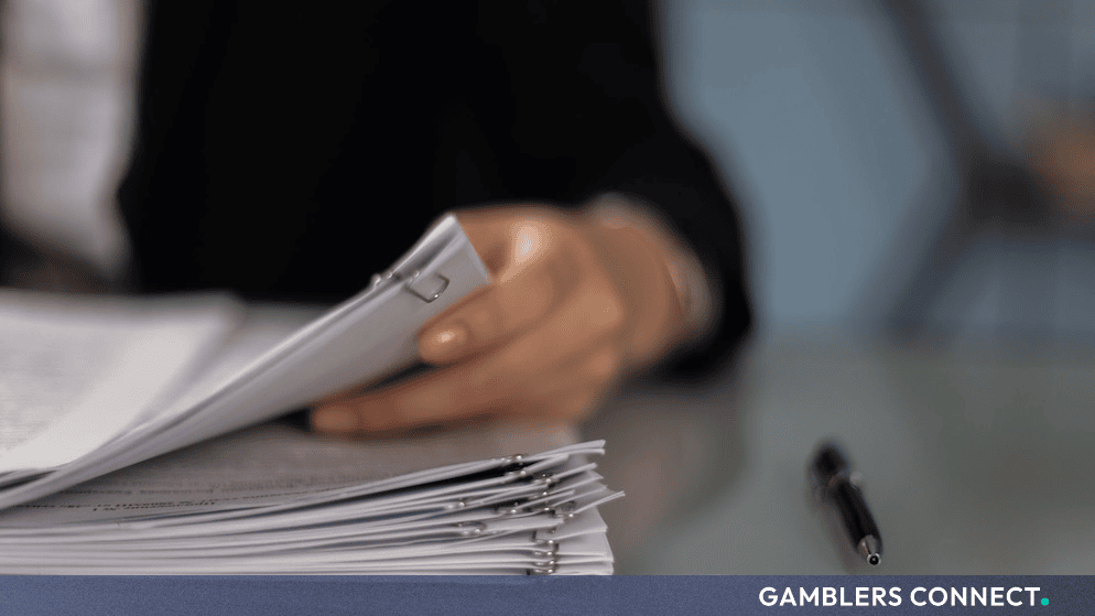 Professional reviewing legal documents and paperwork representing licensing procedures for the Dutch Gaming Authority