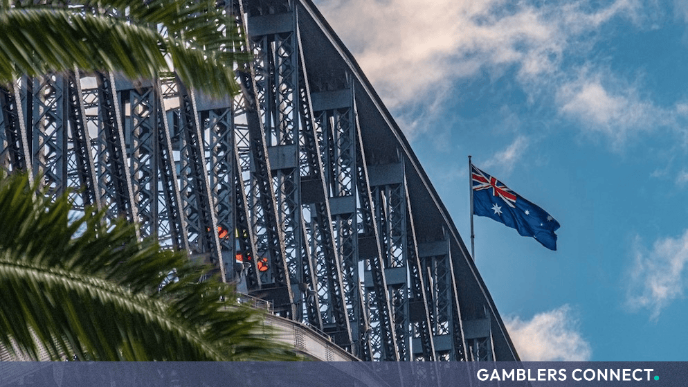 Red and white flag waving against a clear blue sky representing legal proceedings and regulatory oversight in Australia